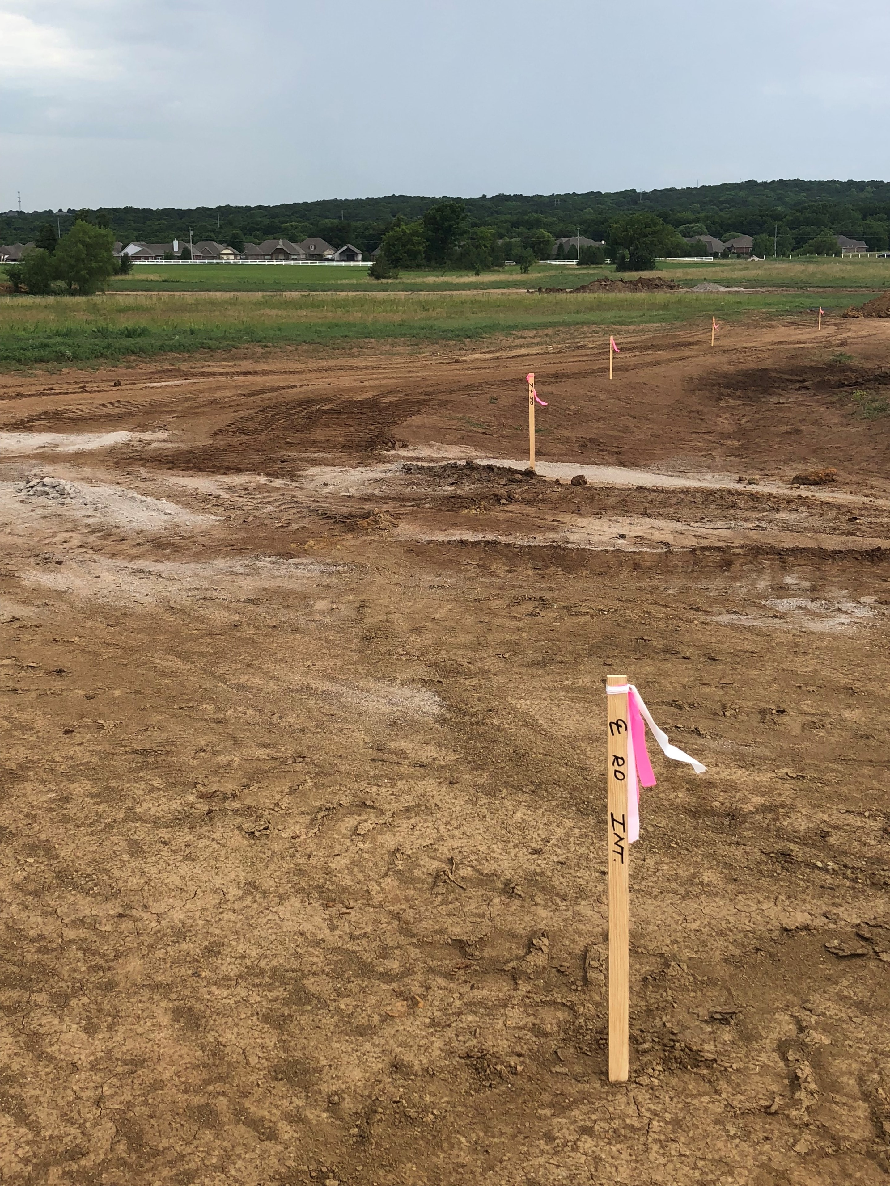 Construction site with survey stakes marking a graded property