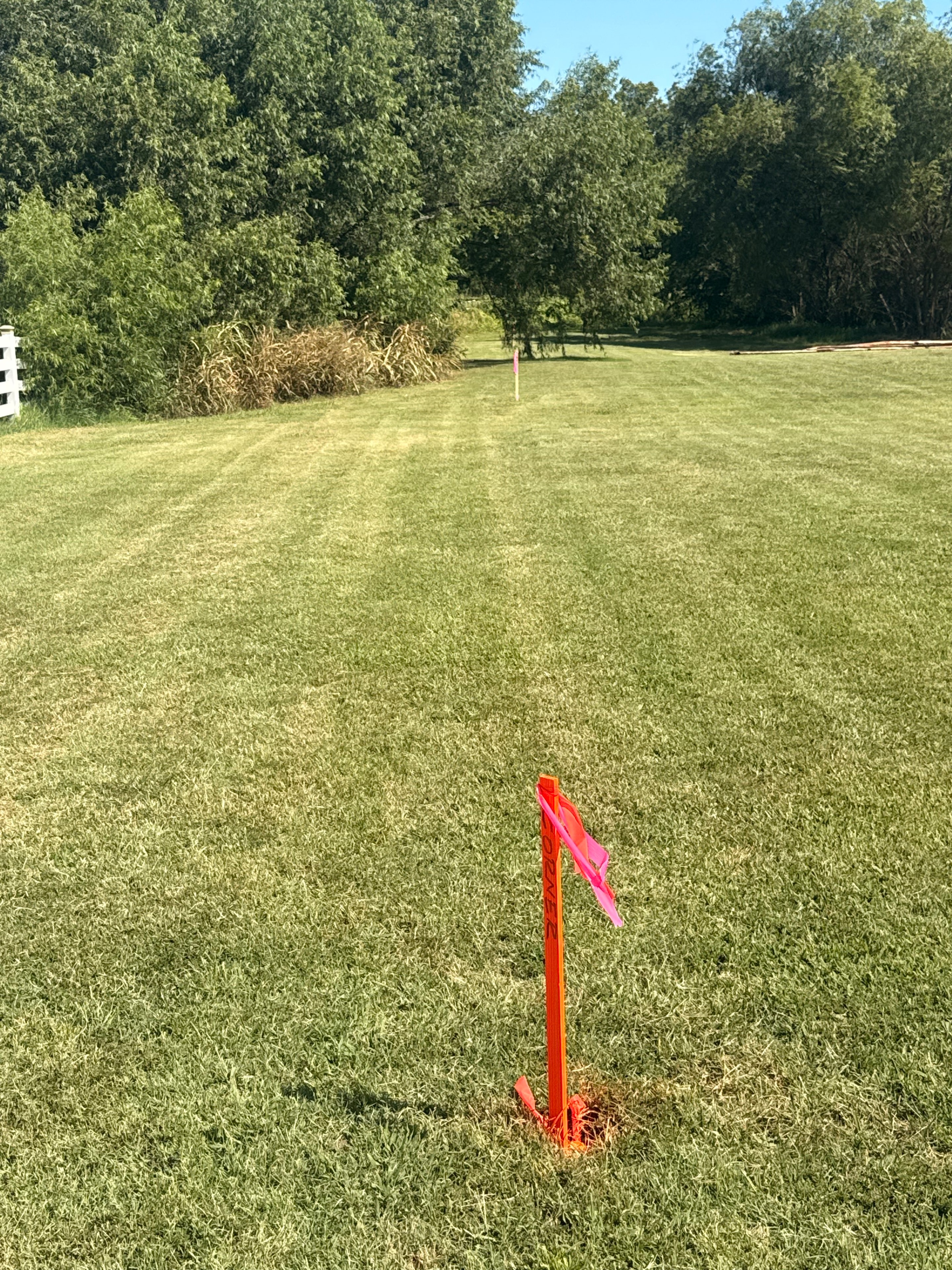 Survey stake marking a grassy field boundary